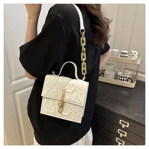 White crossbody bag featuring branch-pattern relief texture and golden chain strap detail