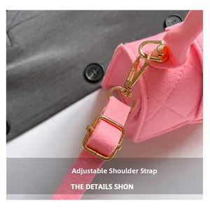 Close-up of pink quilted felt handbag showing adjustable shoulder strap with gold buckles