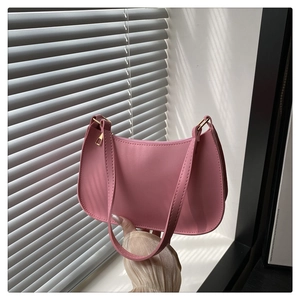 Detailed view of pink shoulder bag with gold zipper and smooth synthetic leather texture