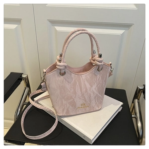 Détail du sac seau rose à motif marbre avec anses tissées et logo doré brillant