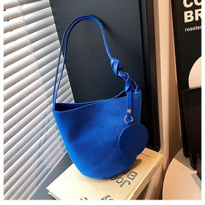 Détail du sac seau bleu Klein en daim avec bandoulière nouée et petite pochette