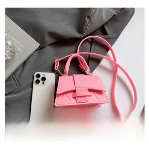 Mini pink quilted handbag compared with a smartphone to show its compact petite size