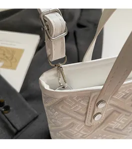 Detailed close-up of textured jacquard fabric and silver metal hardware on a bucket bag