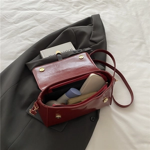 Sac bandoulière vintage en cuir rouge foncé avec boucle dorée et intérieur spacieux