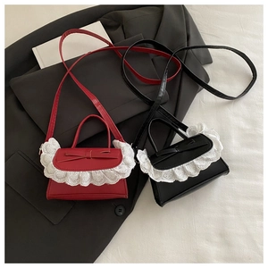 Detailed top view of red and black crossbody bags with lace trim and bow accents