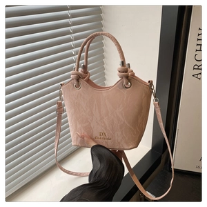 Gros plan détaillé du sac seau rose plissé avec poignée ronde et finitions argentées
