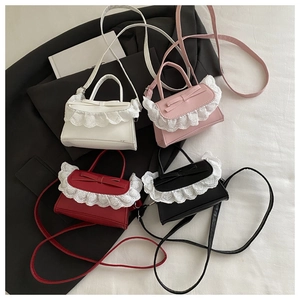Close-up of four colors of ballet style crossbody bags with lace trim and leather bows