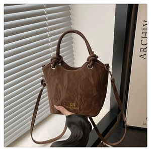 Détail du sac seau en cuir froissé marron foncé avec logo doré DX Do&thinks gravé