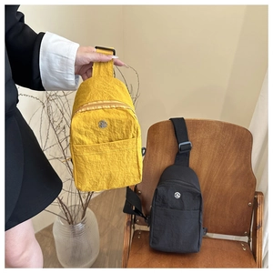 Close-up of waterproof nylon chest bags in yellow and black with adjustable straps