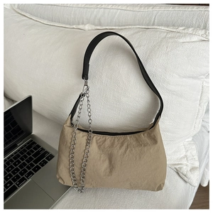 Détail du sac demi-lune en nylon kaki avec chaîne argentée et ordinateur portable