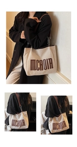 Detail of canvas tote bag with leather chain strap and MCAOIR lettering print