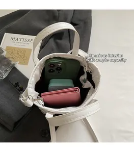 Internal view of white ethnic bucket bag showing capacity for phone and wallet