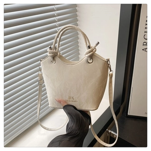 Détail d'un sac seau blanc cassé avec texture marbre et poignée en corde