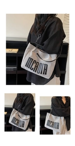 Detail view of large canvas tote bag featuring MCAOIR letters and metallic ring strap