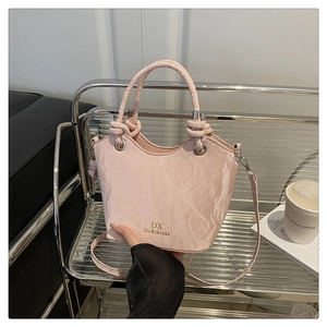 Détail du sac seau rose clair texturé avec anneaux argentés et bandoulière réglable