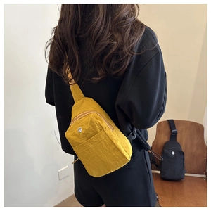 Detailed side view of yellow waterproof nylon chest bag with adjustable strap and M logo