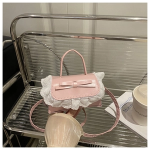 Detail of pink PU leather handbag featuring a sweet bow and white heart lace trim