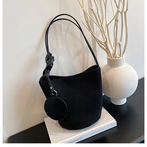 Détail du sac seau en velours noir avec bretelles nouées et petite pochette ronde