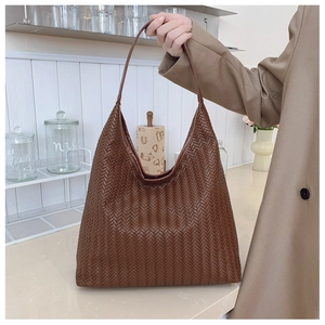 Detail of a brown woven hobo bag showing high-quality synthetic leather and handle texture
