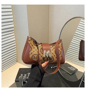 Detail of vintage patterned baguette bag featuring silver M-shaped metal buckle and strap