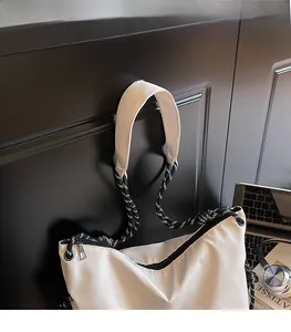 Detail of white nylon messenger bag with black and white woven rope strap and shoulder pad