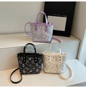 Three bucket bags in lavender, black, and cream with geometric woven textures