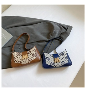 Detail of vintage baguette bags with M monogram print and golden metal magnetic buckles