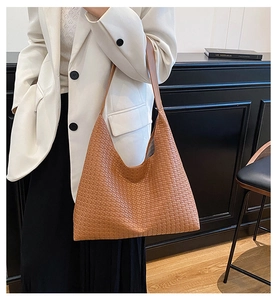 Detail of caramel brown woven leather tote bag showing intricate texture and strap