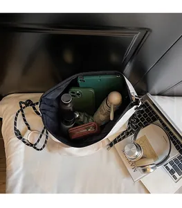 Spacious interior of white canvas tote bag showing tablet, phone, and umbrella storage
