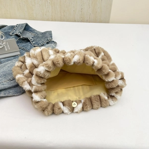 Striped plush tote bag with brown fur patches and yellow lining in a top-down view