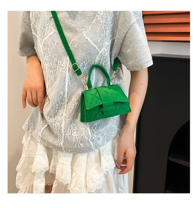 Detail of green quilted felt mini bag featuring diamond stitching and adjustable strap