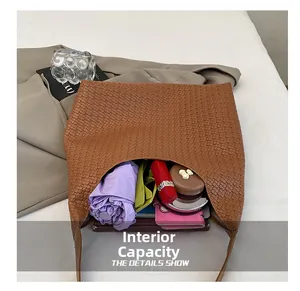 Detail showing internal capacity of brown woven tote bag with daily essentials inside