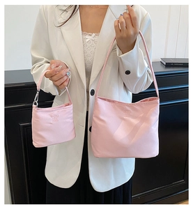 Close-up of pink nylon handbags with letter embossing and lightweight texture detail