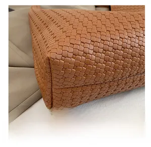 Macro shot of durable brown leather woven texture and artisan stitching on bag base