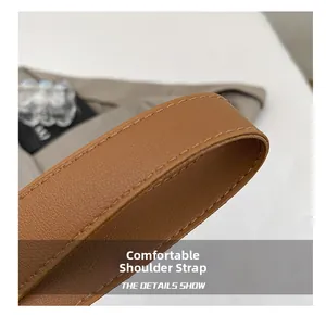 Close-up of a brown leather shoulder strap with meticulous stitching on a chic tote bag
