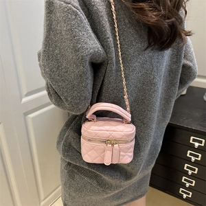 Pink quilted box crossbody bag with gold chain and handle shown on a model outfit