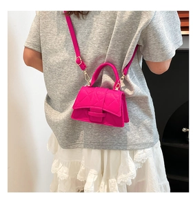 Detail showing fuchsia quilted PU leather mini bag with golden hardware on a model