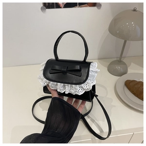 Dettaglio mini borsa nera con fiocco e bordo in pizzo bianco delicato