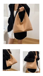 Detail of light brown woven leather hobo bag showing texture and minimalist shoulder strap