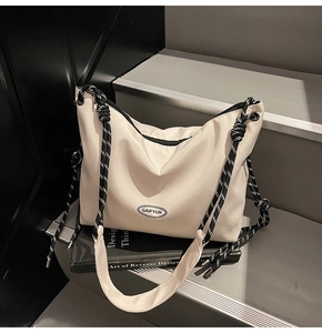 Dettaglio della borsa tote in nylon crema con tracolla a corda e occhielli in metallo