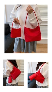 Detail of red nylon tote bag set showing the shoulder strap and small detachable pouch