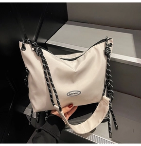 Dettaglio borsa tote beige in nylon con tracolla in corda annodata e logo ovale GAIFYUN