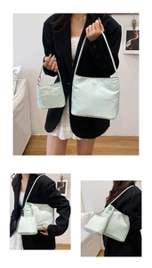 Detail of mint green nylon tote set showing embroidery and matching mini pouch accessory