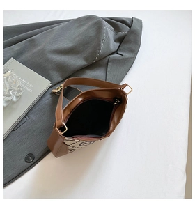 Detailed top view of retro beige canvas underarm bag with M-letter pattern and leather strap