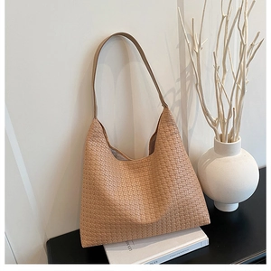 Detail of light brown woven hobo tote bag texture on a minimalist decorative setting