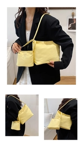 Close-up of bright yellow nylon tote bag with small pouch and embroidered lettering