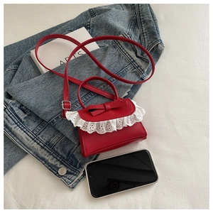 Mini borsa rossa con fiocco e pizzo bianco su una giacca di jeans