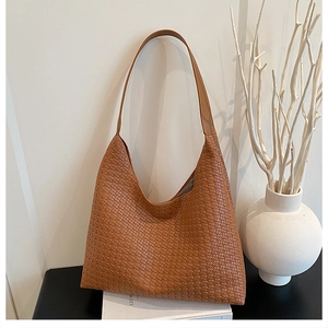 Detailed view of the woven caramel leather texture on a high-quality hobo shoulder bag