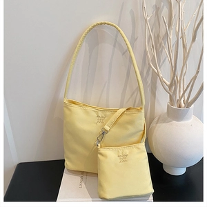 Detail of light yellow nylon bucket bag with embroidery and matching mini zipper pouch