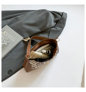 Detail view of printed baguette bag showing internal storage for cosmetics and daily items